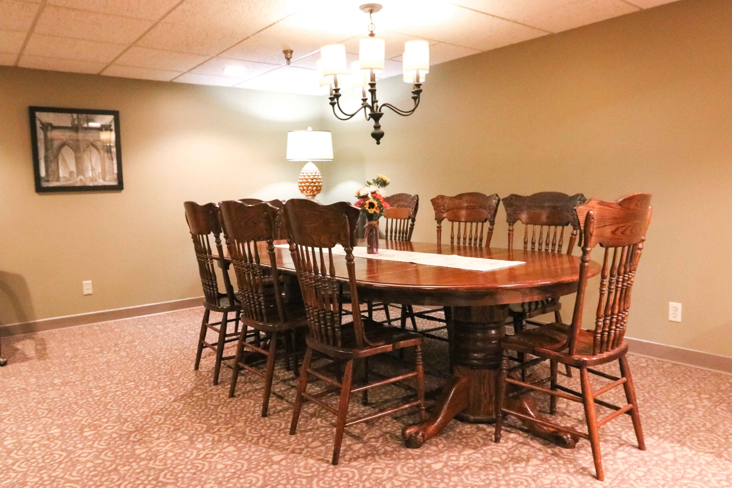 Interior image of the formal dining room with a sturdy wooden table and 8 chairs at Inspirations of Northbrook.