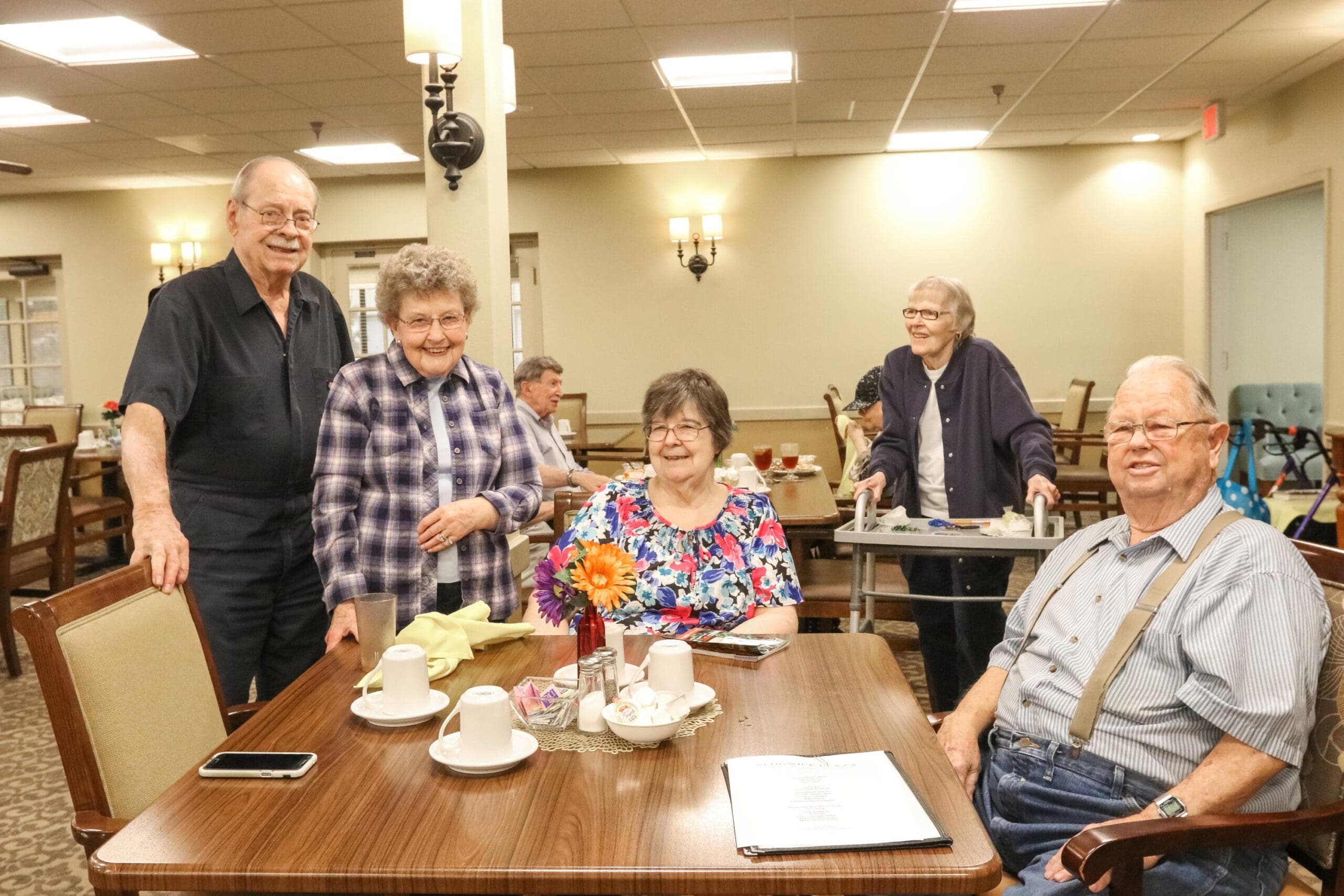 IMG_9751 - Inspirations of Northbrook Residents sit and stand together in the dining room, enjoying a delicious meal at Inspirations of Northbrook.