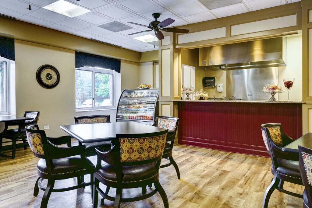 Common area at the Inspirations of Northbrook with a communal kitchen and comfortable chairs and tables.
